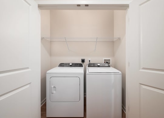 a washer and dryer in a room with white walls and a white door