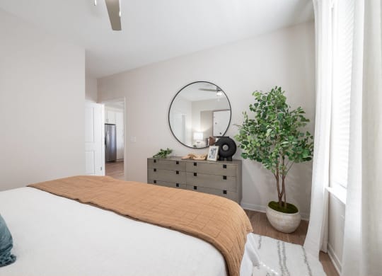 a bedroom with a bed and a dresser with a mirror