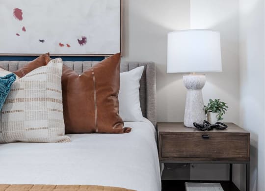 a bedroom with a bed and a lamp and a painting on the wall