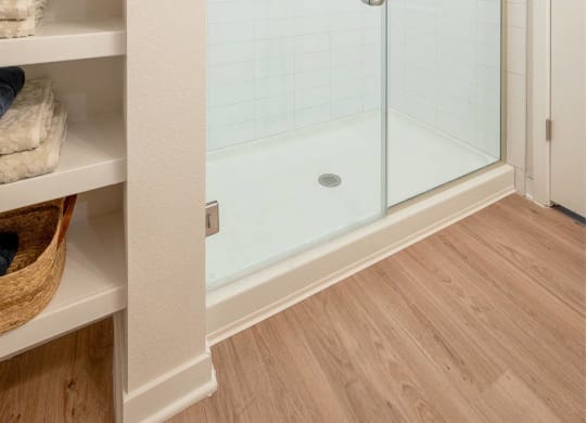 a walk in shower with a glass door in a bathroom