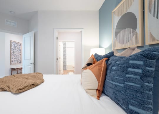 a bedroom with a large bed and a mirror on the wall