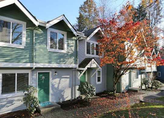 Row of with gabled roofs and autumn foliage at Hidden River Townhomes Apartments, Washington, 98034