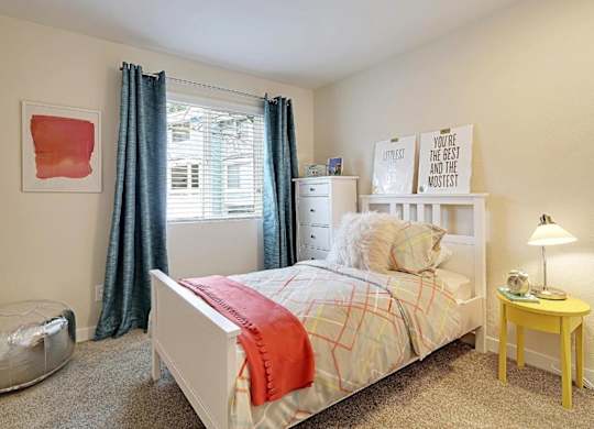 Bright bedroom with white furniture and yellow nightstand at Hidden River Townhomes Apartments, Kirkland, Washington