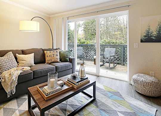Living room with patio doors and modern furnishings at Hidden River Townhomes Apartments, Kirkland, WA 98034