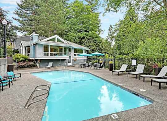 Outdoor swimming pool with lounge chairs and cabana at Hidden River Townhomes Apartments, Kirkland