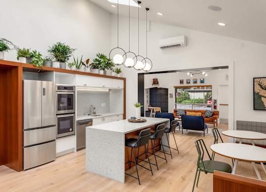 Open concept kitchen with white island and bar seating at Scout Apartments, Washington, 98034