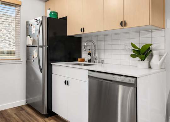 Compact kitchen with white tile backsplash and dishwasher at Scout Apartments, Kirkland, 98034
