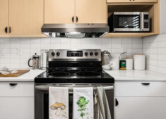 Kitchen with stainless steel stove and white countertops at Scout Apartments, Kirkland, WA 98034