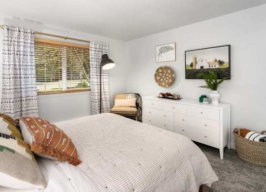 Bedroom with white dresser and natural light at Scout Apartments, Kirkland