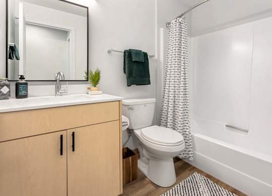 Bathroom with white tub and shower curtain at Scout Apartments, Washington