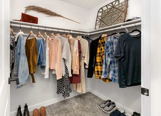 Walk-in closet with organized clothing storage at Scout Apartments, Washington, 98034