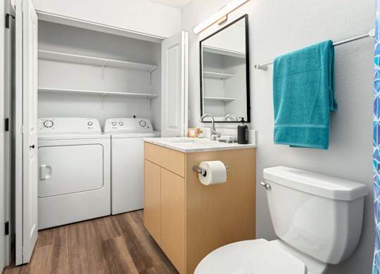 Bathroom with laundry closet and wood vanity at Scout Apartments, Kirkland, WA