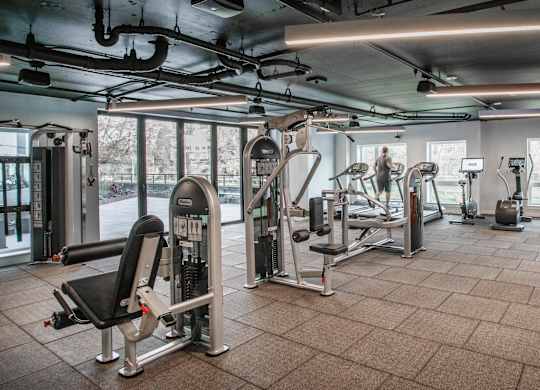 A gym with a variety of equipment including treadmills, weights, and exercise machines.at Axle, Seattle, WA 