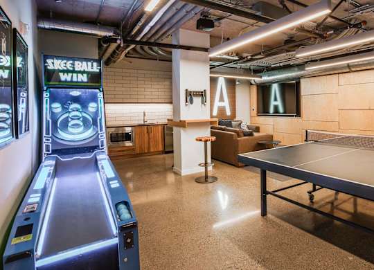 A room with a ping pong table and a bowling alley simulator.at Axle, Seattle Washington 