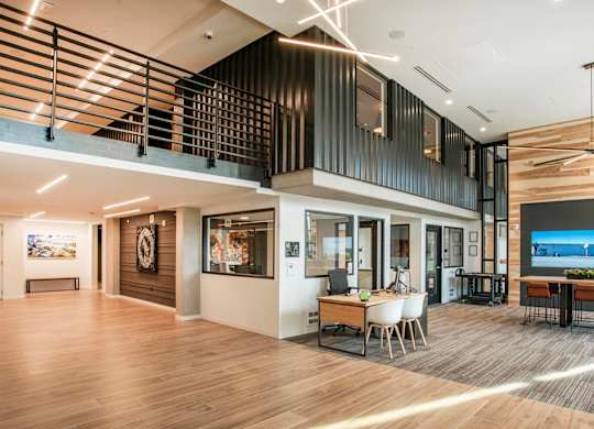 A modern interior space with a wooden floor and a balcony with a railing.at Axle, Seattle, 98119 