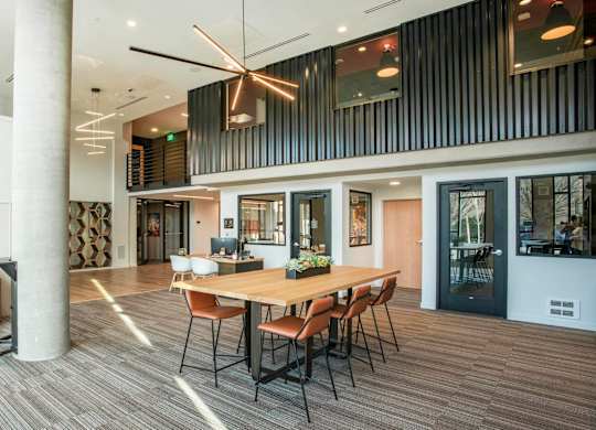 A modern office space with a long table and chairs, a ceiling fan, and a large painting on the wall.at Axle, Washington, 98119