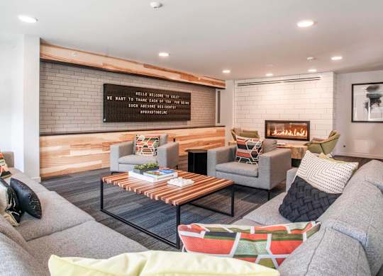 A living room with a grey couch, a coffee table, and a wooden wall.at Axle, Seattle, WA 
