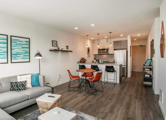 A modern living room with a grey sofa and a wooden dining table.at Axle, Washington, 98119