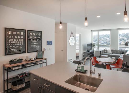 A modern kitchen with a large island and pendant lights.at Axle, Seattle, 98119 