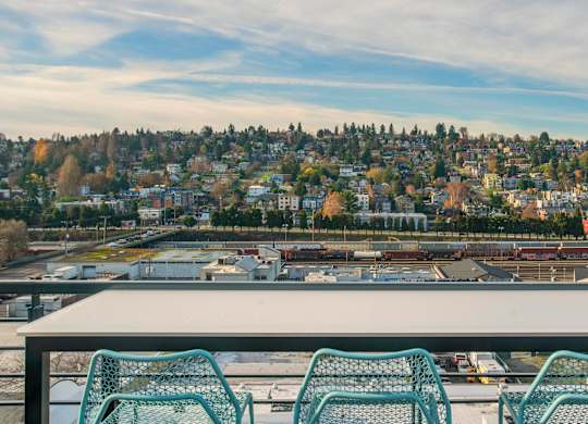A table with four chairs is in front of a scenic view of a city.at Axle, Seattle 