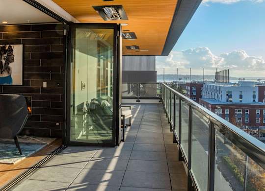 A balcony with a glass door leading to a patio.at Axle, Washington 
