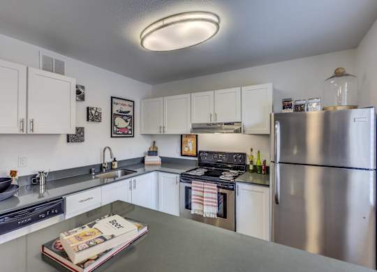 A modern kitchen with white cabinets and stainless steel appliances.