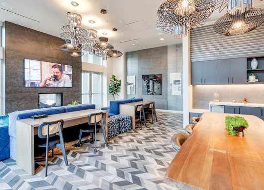 A modern office space with a long wooden table and blue chairs.