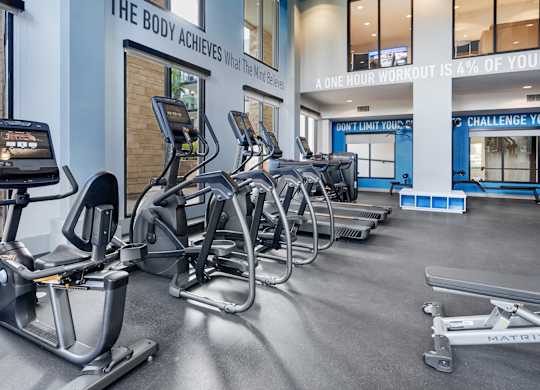 A gym with a row of exercise bikes and a sign that says