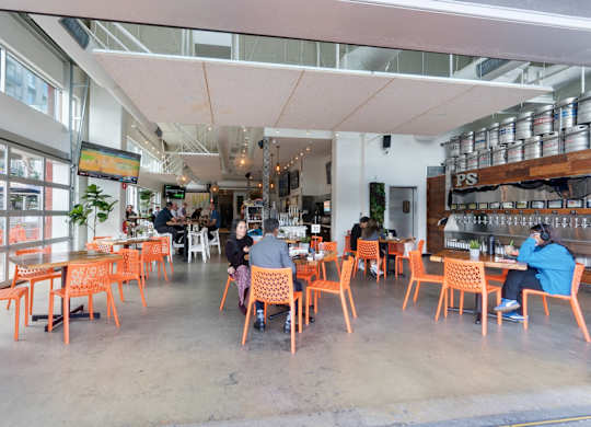 A group of people are sitting at tables in a brightly lit restaurant.
