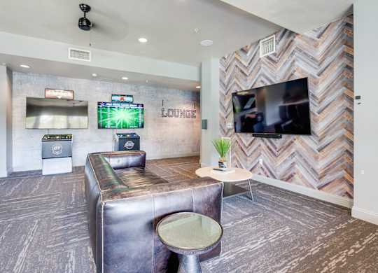 A room with a couch, a chair, and a television.