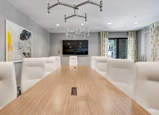 A conference room with a long table and chairs.
