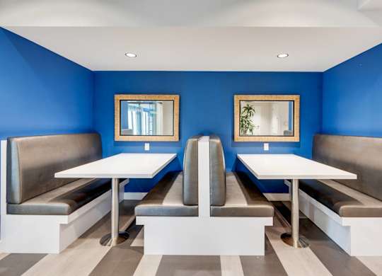 A blue and white restaurant with two tables and two benches.