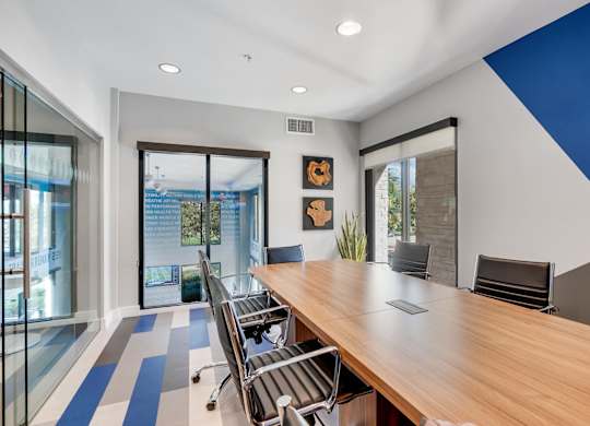 A conference room with a long table and chairs.