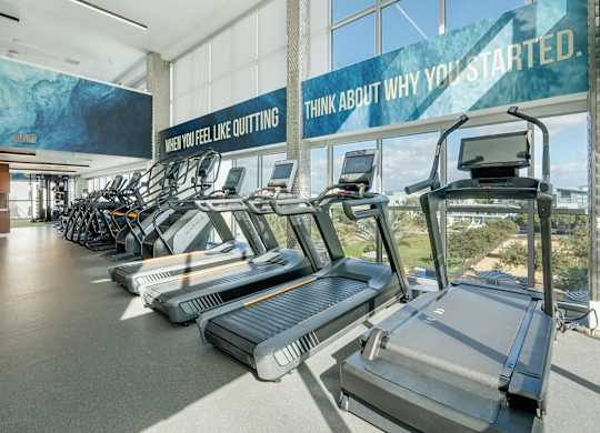 A gym with treadmills and a sign that says
