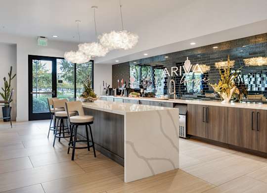A modern kitchen with a bar area and a dining table.