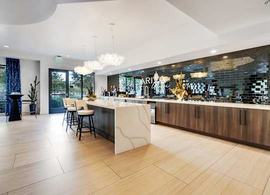 A modern kitchen with a bar area and a dining table.