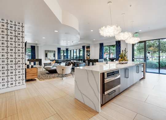 A modern kitchen with a white island and wooden floors.
