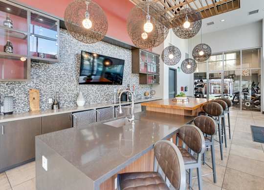 A modern kitchen with a long island and chairs.