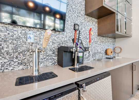 A kitchen with a black and white tiled backsplash and a black dishwasher.