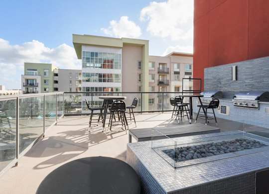 A modern outdoor kitchen area with a grill and seating area.