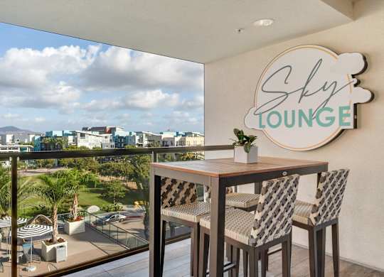 A balcony with a table and chairs and a sign that says Sky Lounge.