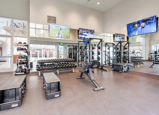 A gym with a variety of equipment including treadmills, weights, and exercise machines.