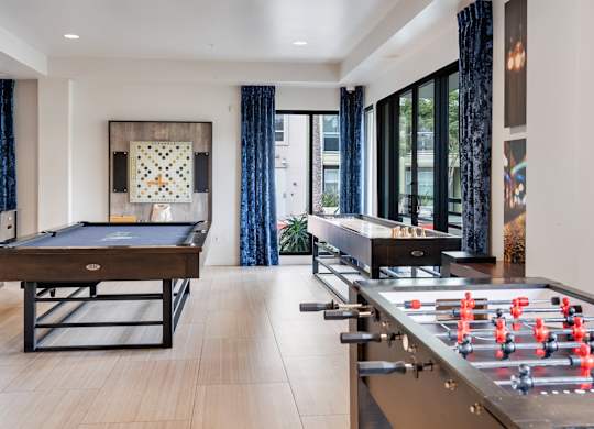 A foosball table is in a room with a pool table.