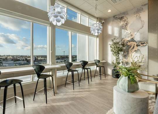 A room with a view of the city through large windows.