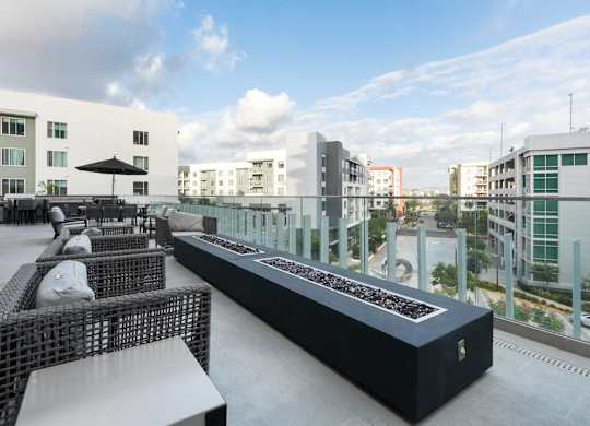 A black and white outdoor seating area with a long table and chairs.