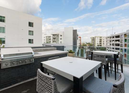 A patio with a table and chairs overlooking a cityscape.
