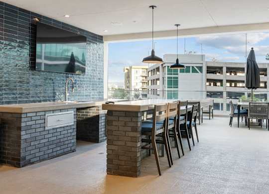 A modern bar area with a television and a view of the city.