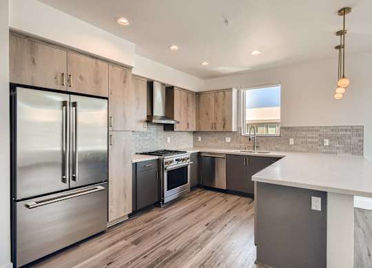 A modern kitchen with a stainless steel refrigerator and wooden cabinets.