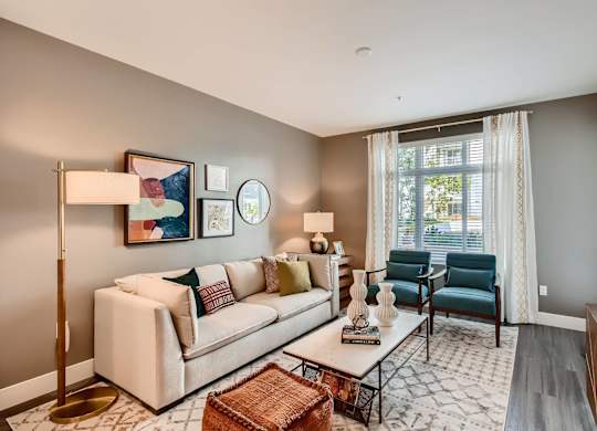 A living room with a white couch, a coffee table, and a painting on the wall.