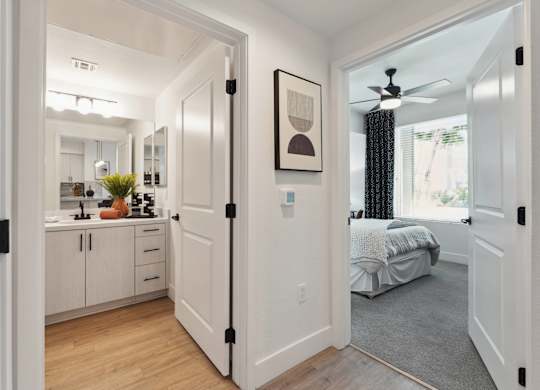 A white hallway with a bedroom at the end.